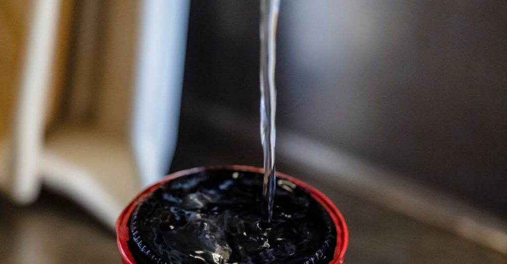 Close-up of water flowing into a film developing tank in a sink.